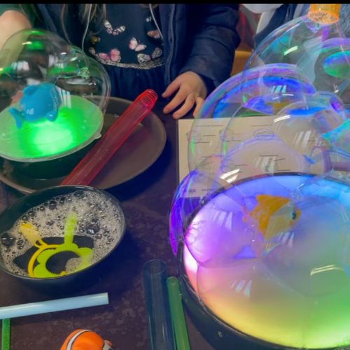 A table full of bubbles made by children at a bubble science party